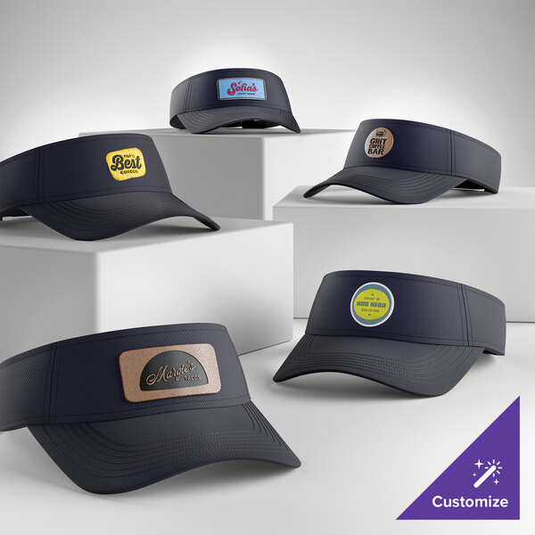 A collection of customizable graphite moisture-wicking visors displayed on white blocks.