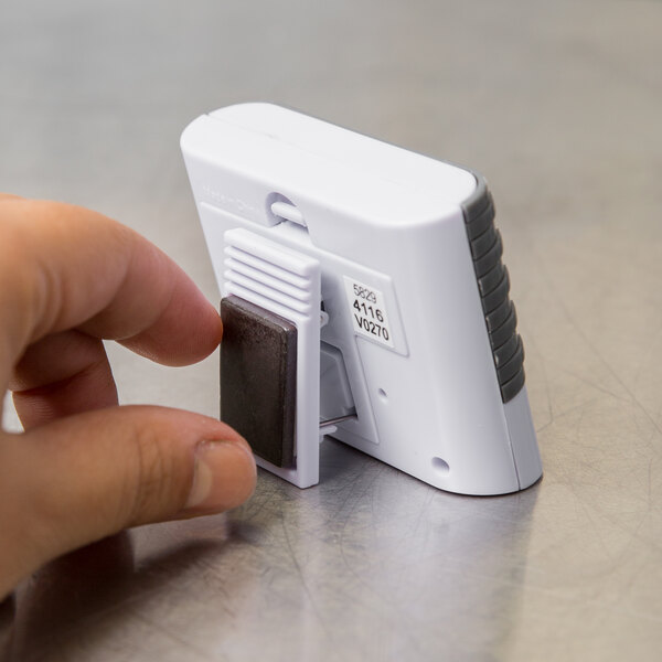 A person using a Taylor digital kitchen timer.