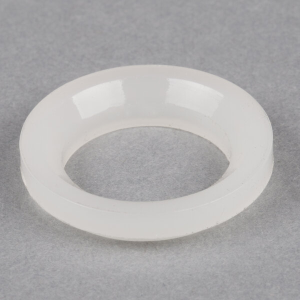 A white round object with a black handle on a grey surface.