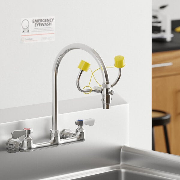 A chrome-plated brass universal faucet mount eyewash with yellow caps attached to a laboratory sink.
