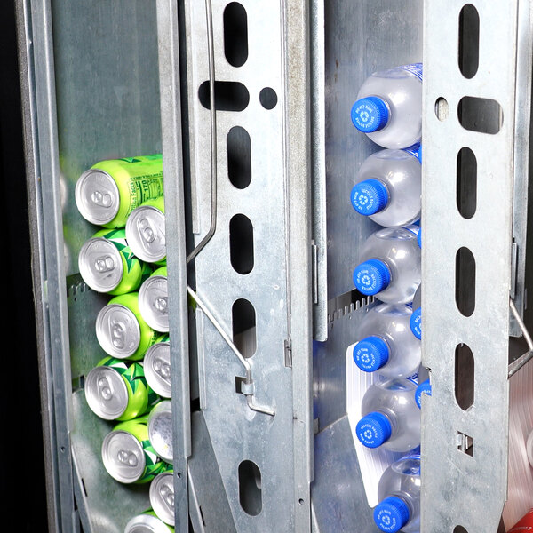 A vending machine interior stocked with cans and bottles of beverages.