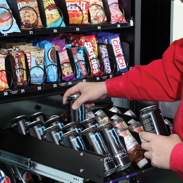 A person taking a beverage from a VEND MACH 29 SLT COMBO vending machine.