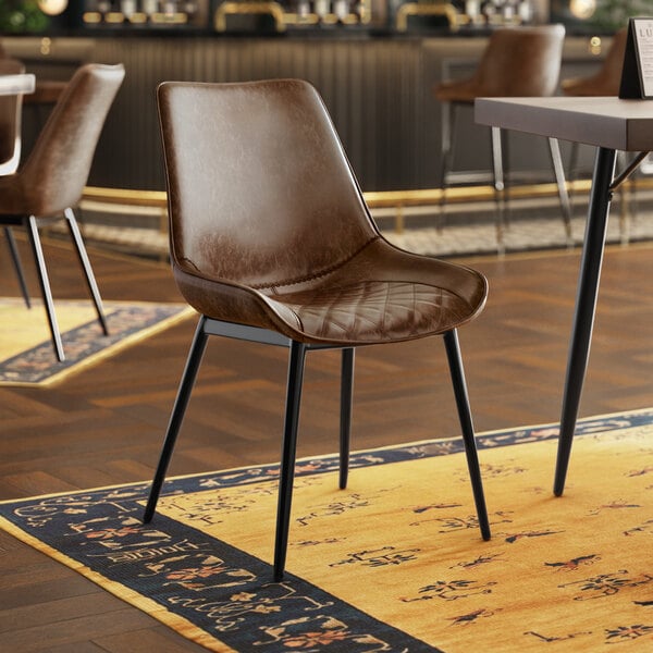 A brown leather Lancaster Table & Seating chair with black legs.