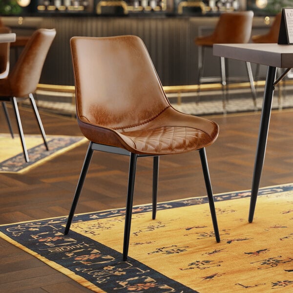 A Lancaster Table & Seating black chair with a brown tufted vinyl seat.