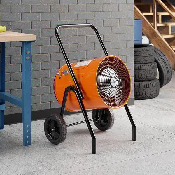 A portable electric salamander heater with an orange cylindrical body, black handle, and wheels for mobility.