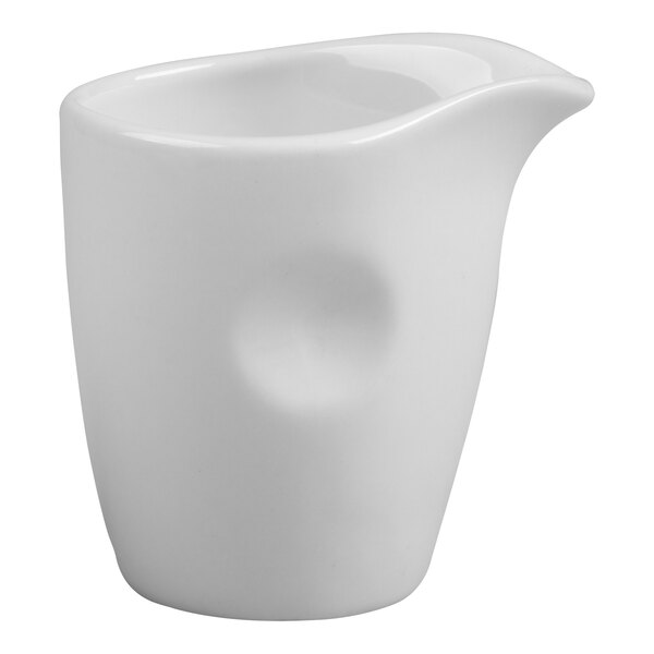 An ivory porcelain creamer with a handle on a white background.