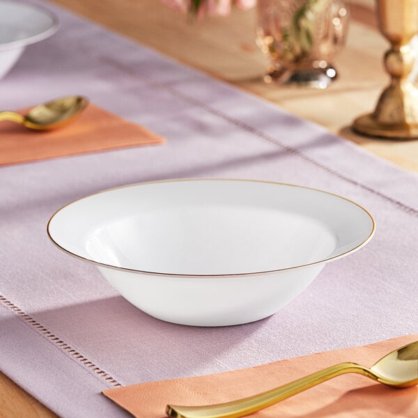 A white bowl with a gold rim on a table.