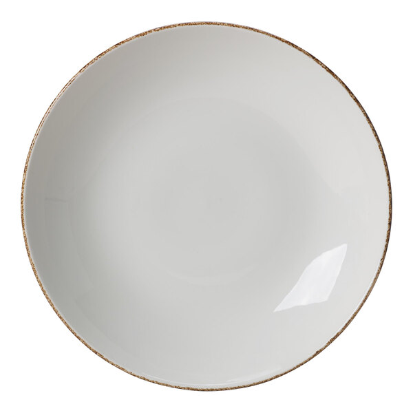 A white porcelain coupe bowl with a brown speckled rim.