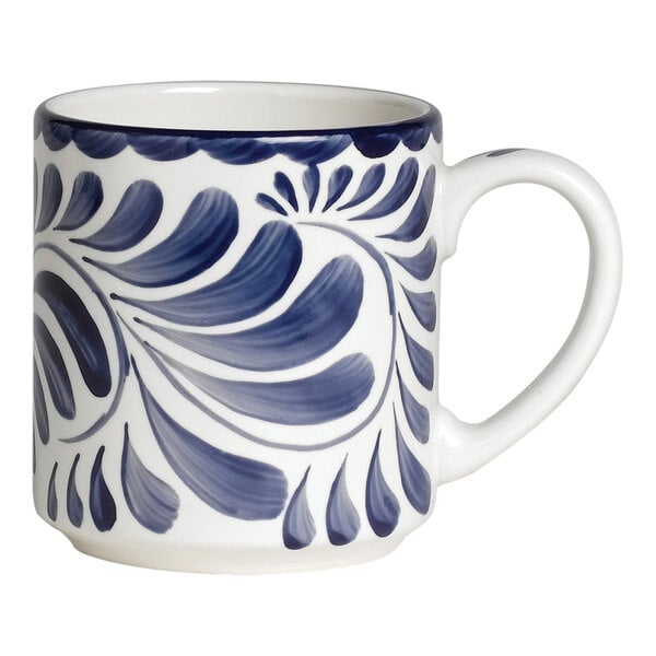 A white porcelain coffee mug with blue and white designs on it.