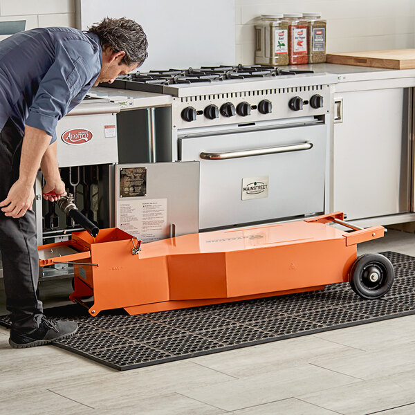 A man using a Fryclone fryer oil shuttle to open a metal object.