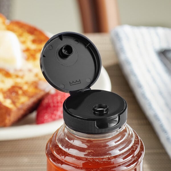 A jar of honey with a 38/400 black plastic flip top lid.