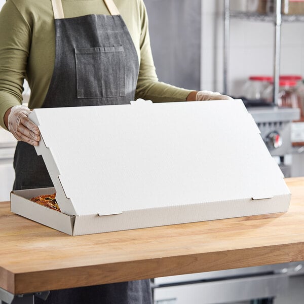 A woman holding a white Choice flatbread box.