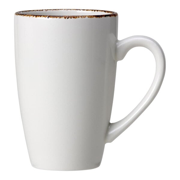 A white porcelain mug with a handle and brown specks on the rim.