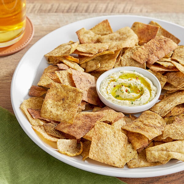 A plate of Issa's Za'atar and thyme pita chips with a bowl of dip.