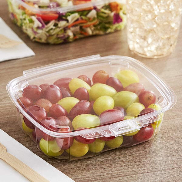 A clear Good Natured GoodGuard plastic container filled with grapes and other fruit.