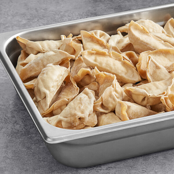 A tray of Chef One Chicken and Vegetable Whole Wheat Dumplings in a metal pan on a counter.