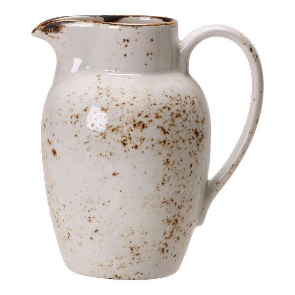 A white pitcher with brown speckled spots.