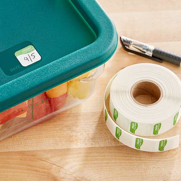 A plastic container with a Dissolvable Friday Day of the Week label next to a roll of white tape.