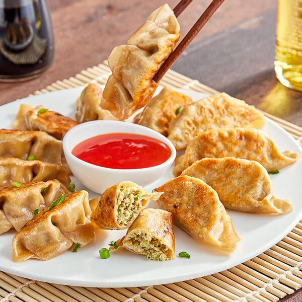 A plate of Chef One whole wheat vegetable and tofu dumplings with dipping sauce.