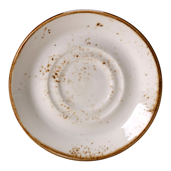 A close up of a Steelite Performance Craft white saucer with brown speckled edges.