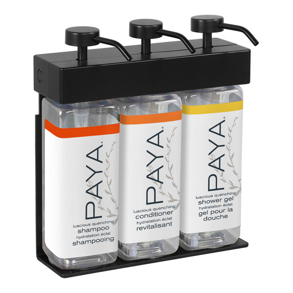 A black wall mounted dispenser with three rectangular bottles of Paya shampoo with white labels.