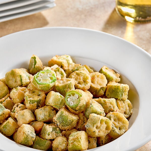 A white bowl filled with breaded okra pieces.