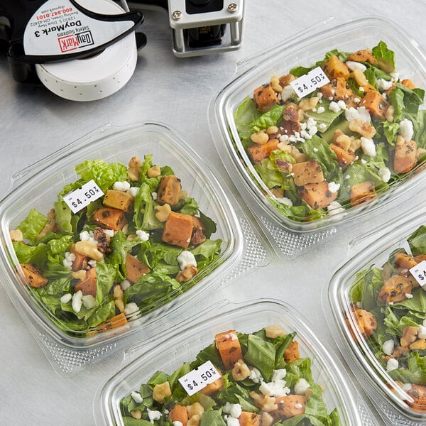 A salad in a plastic container with a DayMark DuraMark Express date coder label.