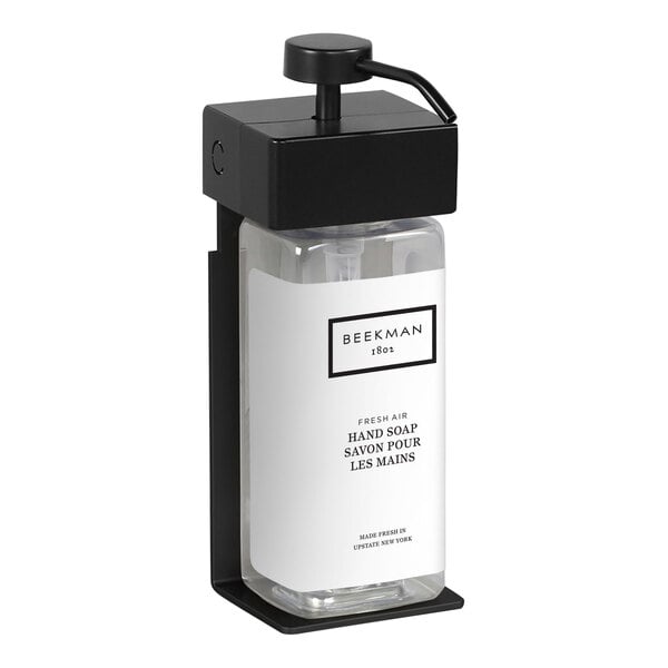 A black rectangular wall-mounted shower dispenser with a white label on the bottle.