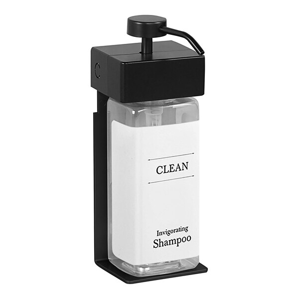 A white rectangular bottle with black accents and a black cap on a black and white wall-mounted soap dispenser.