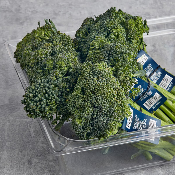A plastic container filled with broccolini.