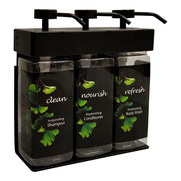 A black wall-mounted dispenser with three rectangular bottles with green ginkgo labels.