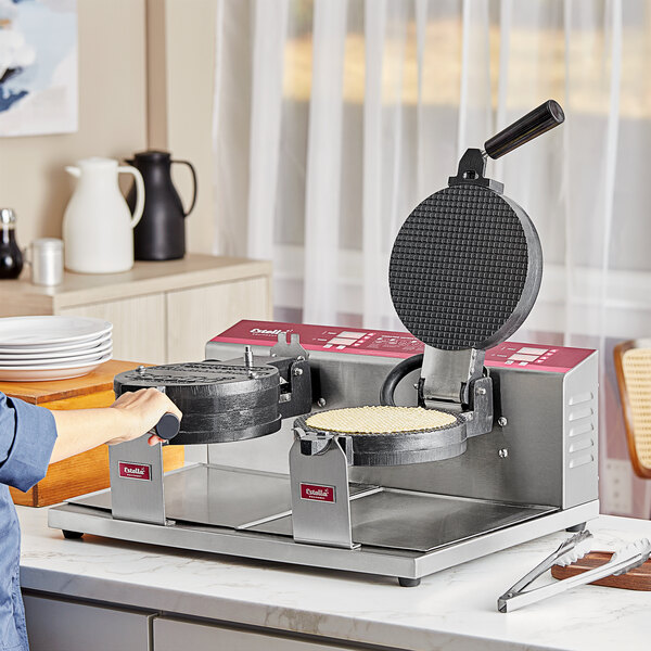 A person using the Estella Double Belgian Waffle Maker to make two waffles.