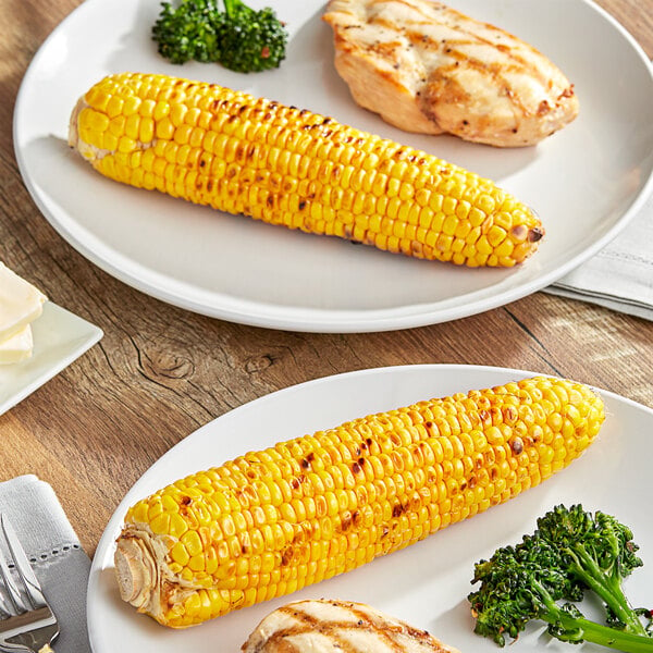 A plate of corn on the cob on a white table.