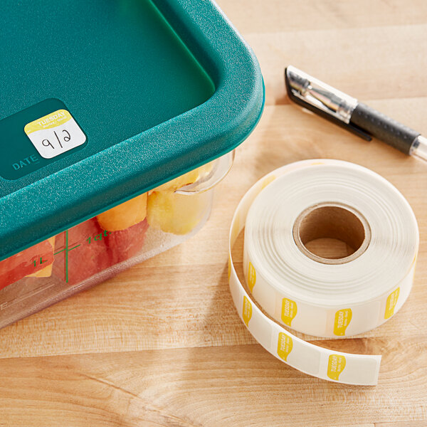 A plastic container of fruit with a DayMark Tuesday date label on it.