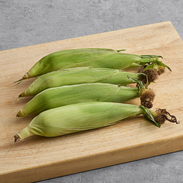A group of fresh bi-colored corn on the cob.