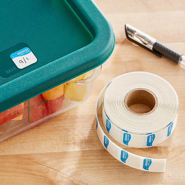 A plastic container with a roll of DayMark Dissolvable Monday Labels and a pen.