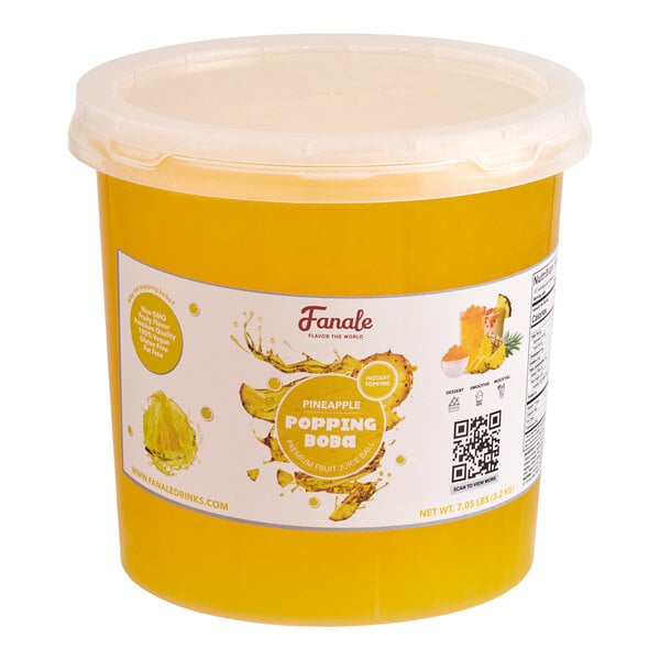 A plastic container of Fanale Pineapple Popping Boba with yellow liquid inside.