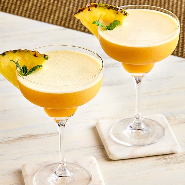 Two glasses of yellow smoothie with Fanale Golden Pineapple Fruit Jam on top.