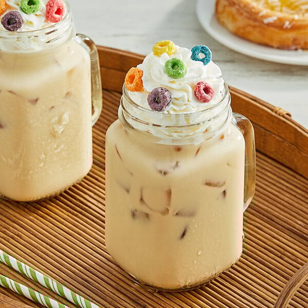 A glass jar of Fanale Pure Cane Sugar Concentrated Syrup with whipped cream on top of a drink.