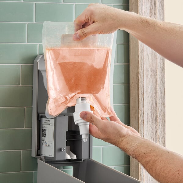 A hand using Lavex foaming antibacterial hand soap in a plastic bag.