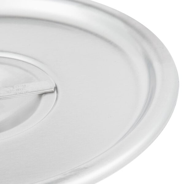 A close-up of a Vollrath stainless steel lid with a metal handle.
