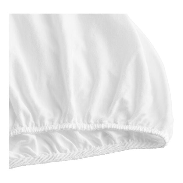 A close up of a white cloth fitted sheet with a ruffled edge.