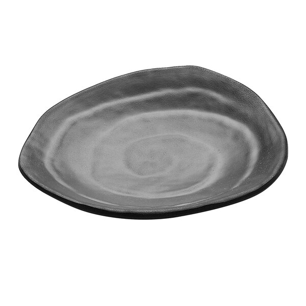 A close-up of a black Elite Global Solutions triangle plate with an irregular edge and a circular spiral pattern on it.