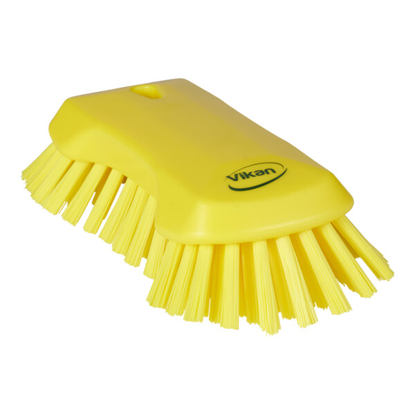 A yellow Vikan scrub brush with a handle and stiff bristles.