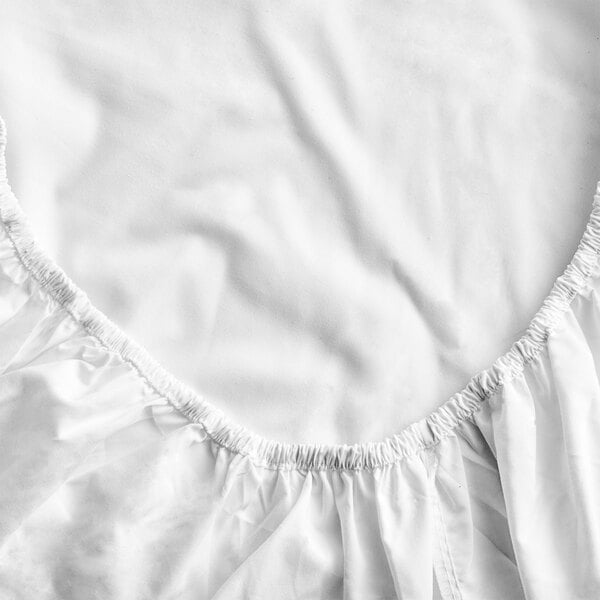 A white Oxford Dormi Bene king size fitted sheet with a ruffled edge.