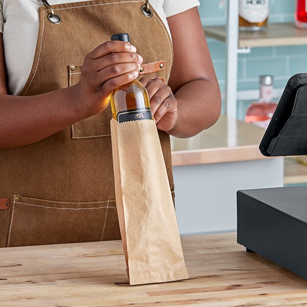 A woman holding a Duro brown paper bag with a bottle of wine inside.