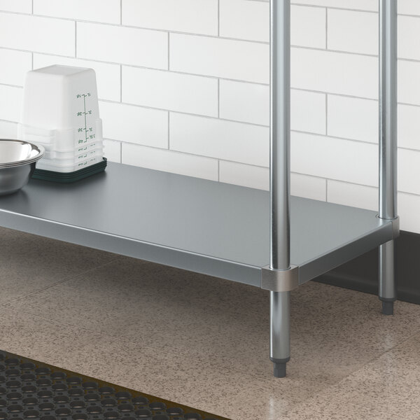 A galvanized metal shelf with a bowl and bowl on it.