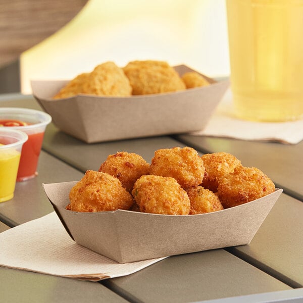 A Southern Champion paper food tray with fried chicken nuggets and ketchup on a table outdoors.