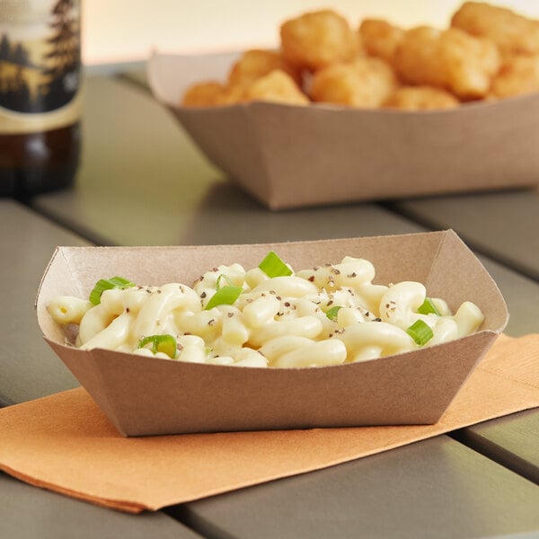 A Southern Champion paper food tray holding macaroni and cheese on a table.