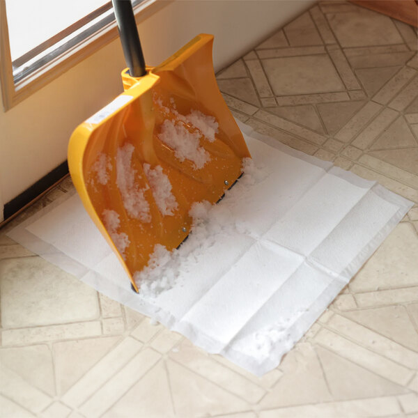 A snow shovel on a Quick Dam absorbent mat.